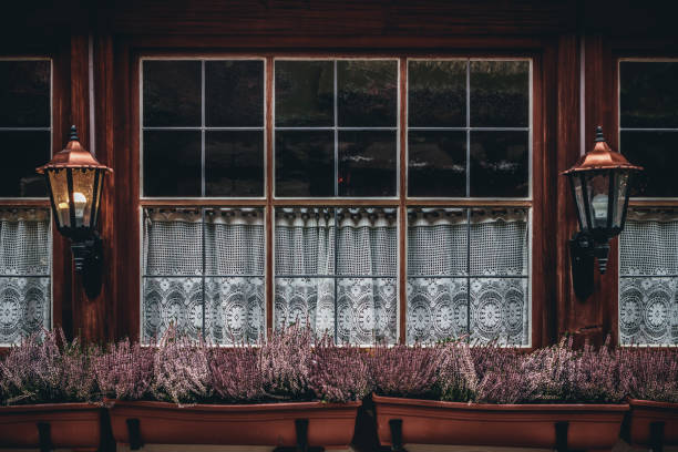 Traditional window with heather flowers and lace curtain.