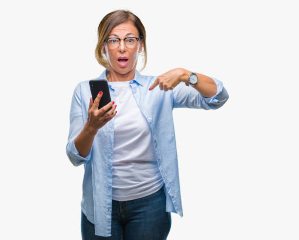istock Middle age senior woman texting sending message using smartphone over isolated background with surprise face pointing finger to himself 1069253752