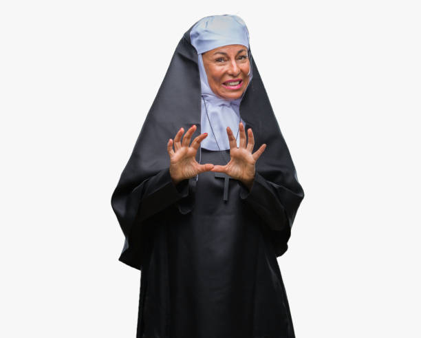 istock Middle age senior christian catholic nun woman over isolated background disgusted expression, displeased and fearful doing disgust face because aversion reaction. With hands raised. Annoying concept. 1069254408