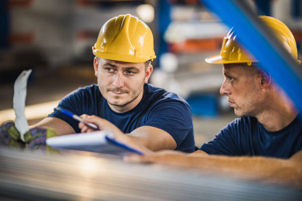 istock Mid adult metal workers cooperating while working in aluminum mill. 1069254946