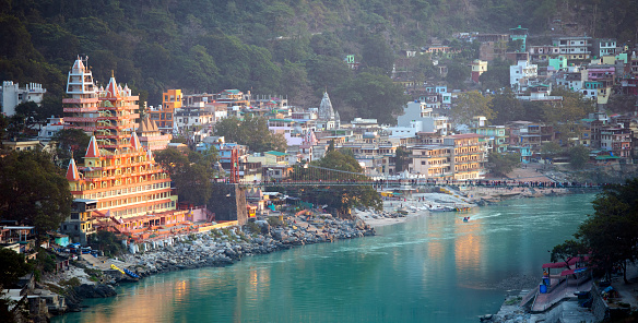Spectacular view of the Lakshman Temple bathed by the sacred river Ganges at sunset. Trayambakeshwar is one of the important holy shrines in Rishikesh, Uttarakhand, India.