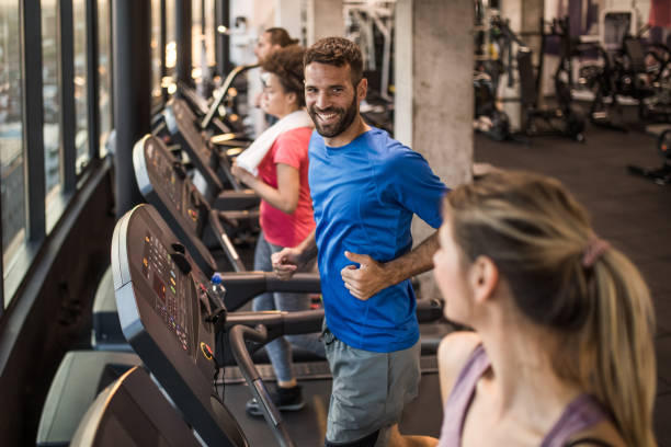 istock Group of athletic people talking while running on treadmills in a gym. 1069265130