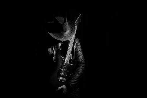 Silhouette of guitar player (guitarist ). Music concept, guitarist in dark. Black and whiite photo.