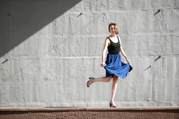 istock young girl posing against a concrete wall, dressed in black, hard light and shadows 1069271850