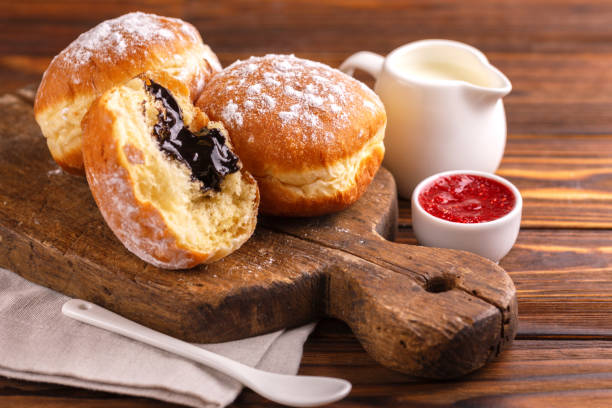 istock Tasty sweet sugary chocolate donuts with raspberry jam and milk on old wooden rustic cutting board 1069272280