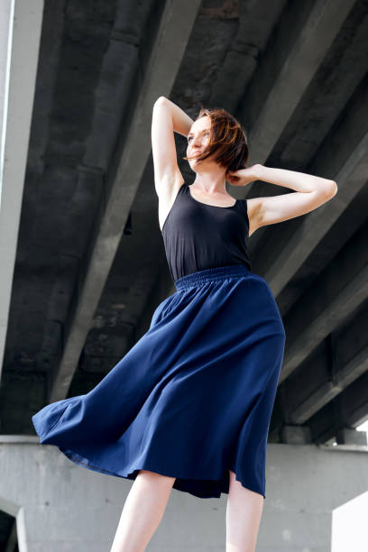 young girl posing under the bridge, dressed in black, modern architecture