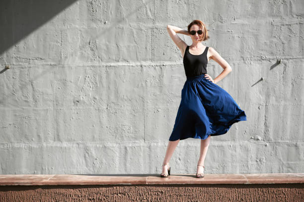 istock young girl posing against a concrete wall, dressed in black, hard light and shadows 1069276554