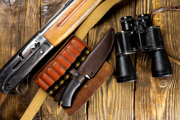 istock Hunting rifle and ammunition lie on wooden background. 1069276726