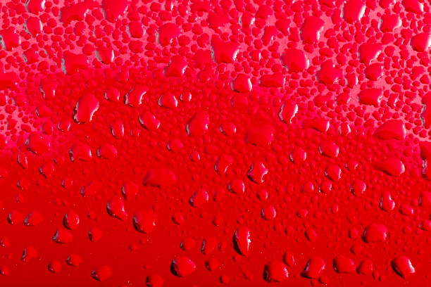 istock Rain drops on red car surface / paint. Red enamel paint refinish 1069283374
