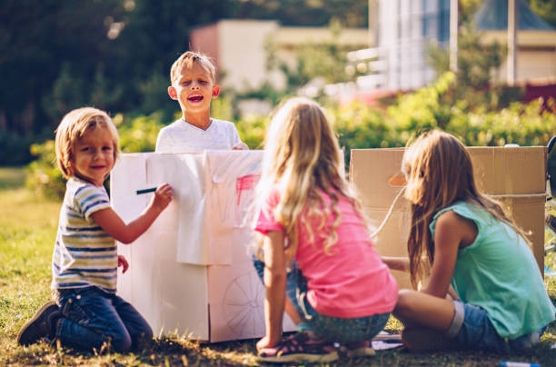 istock Children coloring cardboard boxes in nature 1069283526