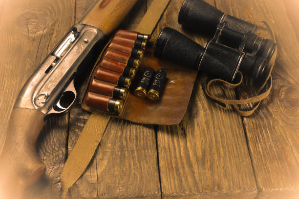 istock Hunting rifle and ammunition lie on wooden background. 1069283808