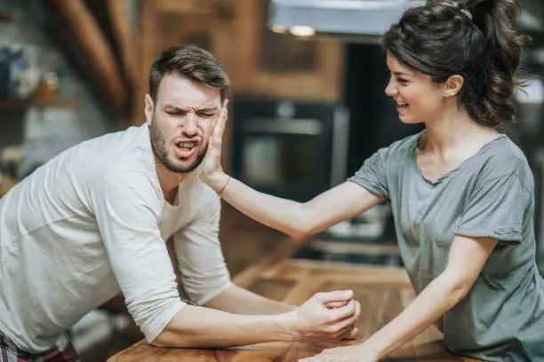 Photo of Woman slapping her boyfriend for making a mistake at home.