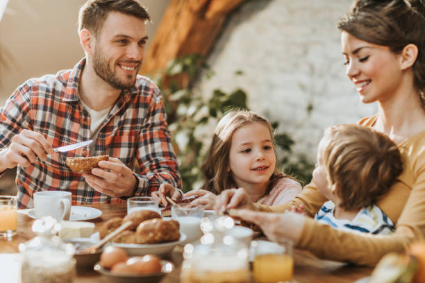 istock Young happy parents enjoying with their kids during breakfast time at dining table. 1069290516