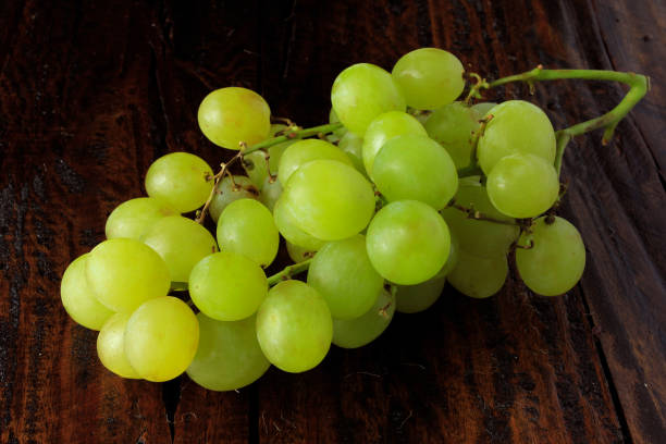 istock bunches of fresh green grapes, on rustic wooden table, close-up 1069290946