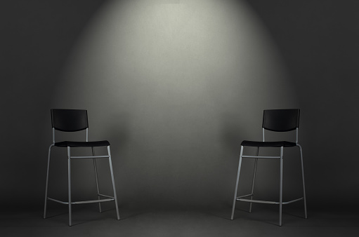 Two black chairs isolated on gray background in the studio with copy space. Job interview room.