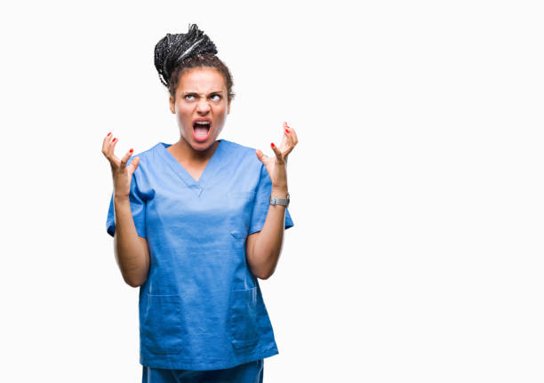 молодые плетеные волосы афро-американской девушки профессиональная медсестра за изолированный фон сумасшедший и сумасшедший кричать и кр - anger child braids braided стоковые фото и изображения