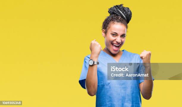 Young Braided Hair African American Girl Professional Nurse Over Isolated Background Very Happy And Excited Doing Winner Gesture With Arms Raised Smiling And Screaming For Success Celebration Concept Stock Photo - Download Image Now
