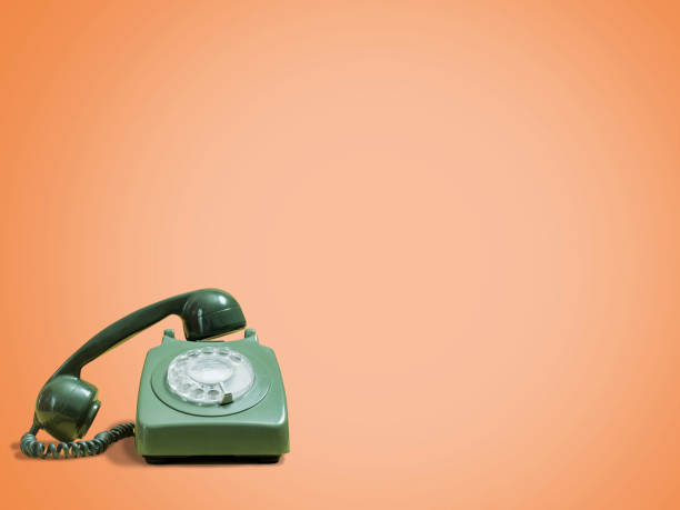 istock Retro green rotary phone with receiver lifted on orange 1069307332