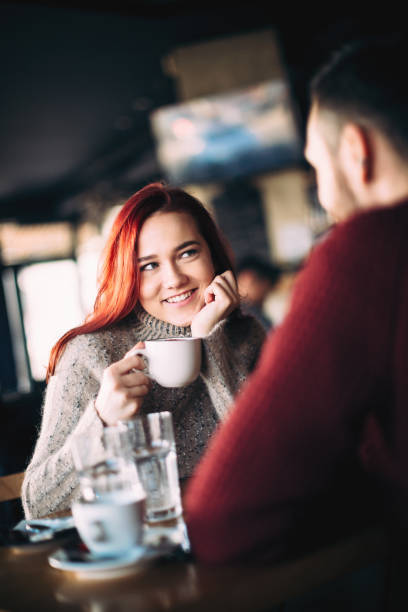 istock Beautiful young couple having coffee and using smart phone 1069308056