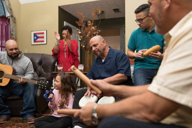 Family and friends dancing and playing musical instruments Multi-generation family and neighbors gather for a parranda. puerto rican ethnicity stock pictures, royalty-free photos & images