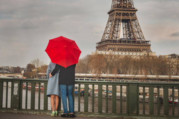 autumn in paris, couple under red umbrella near eiffel tower, fall season - paris france eiffel tower love kissing imagens e fotografias de stock