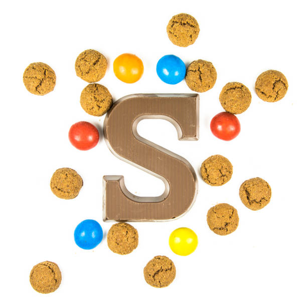 istock Chocolate letter S with bunch of scattered pepernoten cookies 1069321770