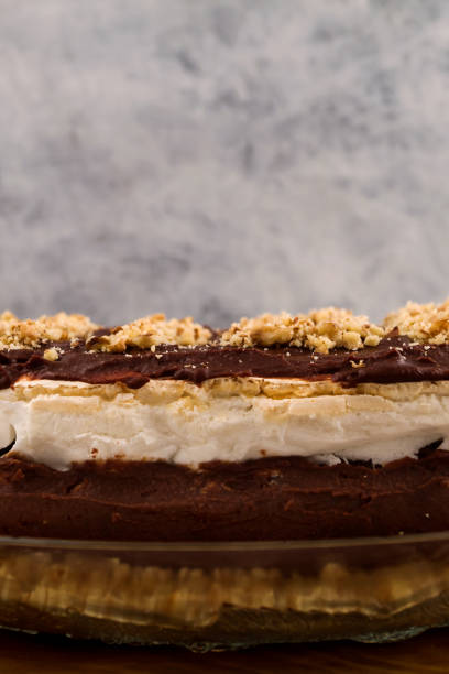 istock Chocolate cake. Brown and white layer. Ground walnut. Wooden background. Vertical. 1069326922