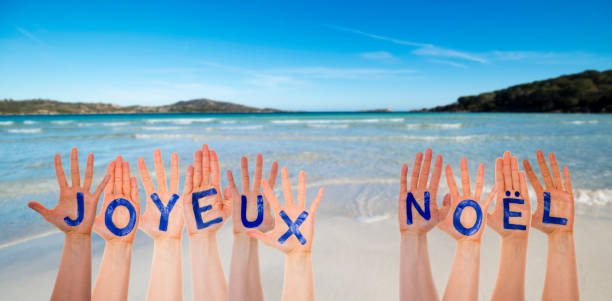 istock Many Hands Building Joyeux Noel Means Merry Christmas, Beach And Ocean 1069331098