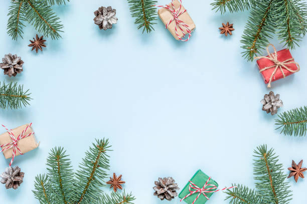 istock christmas composition. frame made of fir branches, star anise, decorations, gift boxes and pine cones on blue background 1069343032