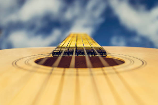 A spannish acoustic guitar held up against the sky