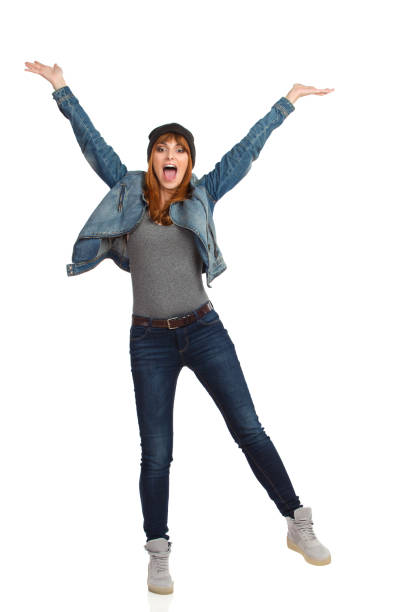 Young Woman Is Standing On One Leg With Arms Outstretched And Shouting