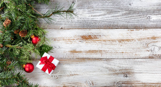 istock Rough Fir branches and Christmas decorations on white rustic wooden background 1069382562