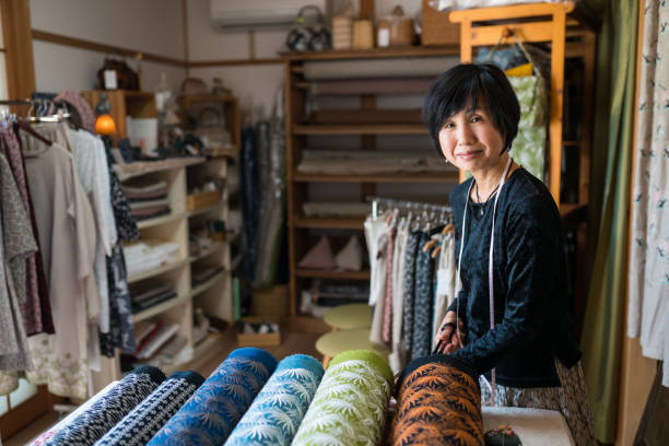 istock Mature woman inspecting the finished textile fabric she designed after manufacturing 1069401310