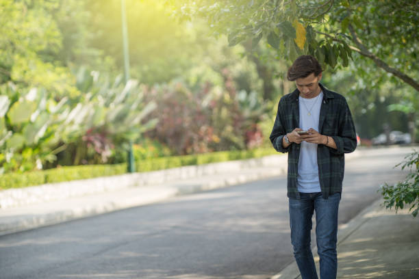 istock young asian with smartphone in a park 1069407998