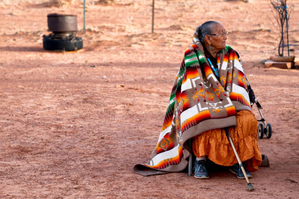 piękna babcia navajo w tradycyjnym ręcznie robionym kocu siedzącym na jej podwórku o zmierzchu - navajo american culture indigenous culture women zdjęcia i obrazy z banku zdjęć