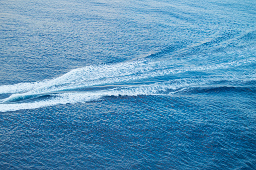 Boat track on the sea, white foam, blue waves, beautiful background