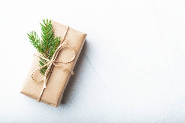 istock Christmas composition. Christmas gift, pine cones, fir branches on stone white background. Flat lay, top view, copy space 1069414830