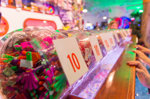 This is the colorful prize counter at a local arcade that gives small prizes in return for tickets earned from playing various games.  In the glass jars are the prizes.  On the front of the jars are labels indicating how many tickets are required for each prize.