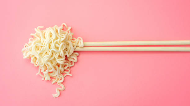 istock Instant noodles and chopsticks on a pink background. 1069416046
