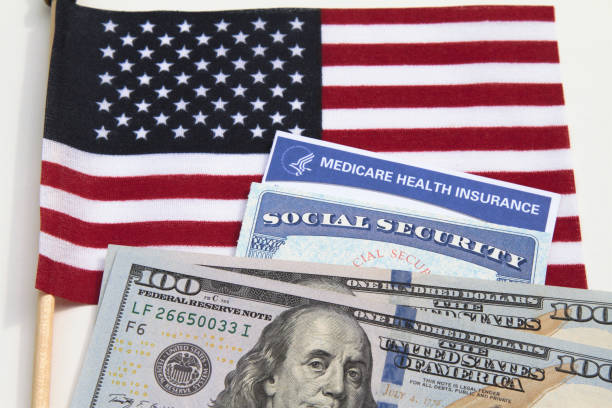 Medicare and Social Security cards with USA flag and currency Medicare and Social Security cards with American flag and currency. Health care and social welfare concept for seniors in the USA. Essential American ID's. social security social security card identity us currency stock pictures, royalty-free photos & images