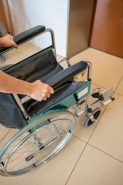 woman 's hand pulling wheelchair from the wheelchair parking area. - physical impairment wheelchair disabled accessibility imagens e fotografias de stock