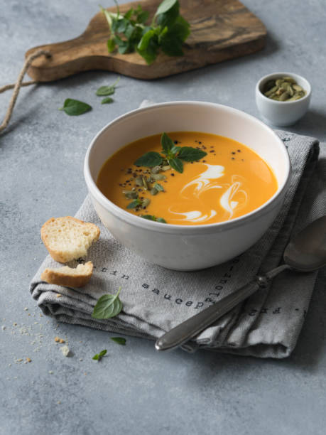 istock Pumpkin cream soup in a white bowl on a gray background 1069426854