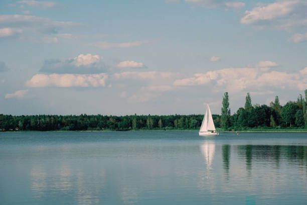 istock Sailing boat on a calm lake with reflection in the water. Serene scene landscape. Horizontal photograph. 1069434584