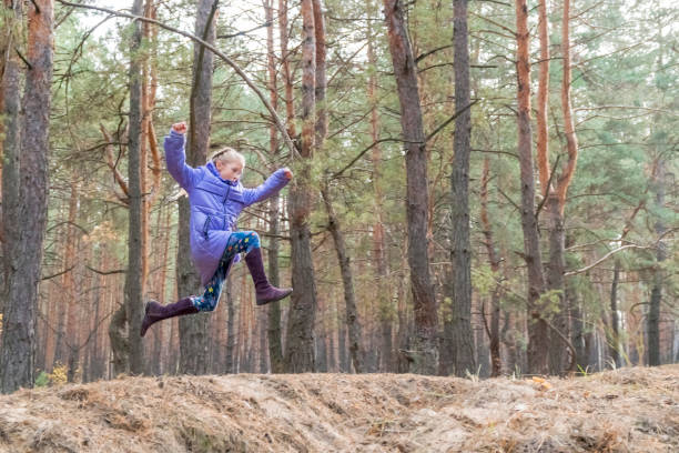 istock girl jumping in the forest 1069434628