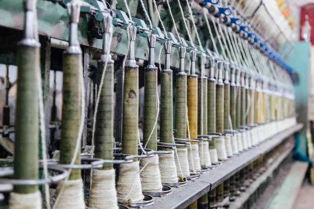 Spinning machinery with spindles and wool yarns, selective focus Spinning machinery with spindles and wool yarns, selective focus. viscose stock pictures, royalty-free photos & images