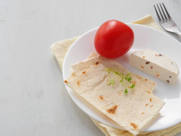 Culinary background with vegetarian breakfast. Soft cheese with fresh vegetables, cress salad and pita bread on white plate. Healthy eating concept. Copy space for your text. stock photo