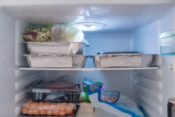 istock Open refrigerator filled with raw food, vegetables and foil package 1069451656