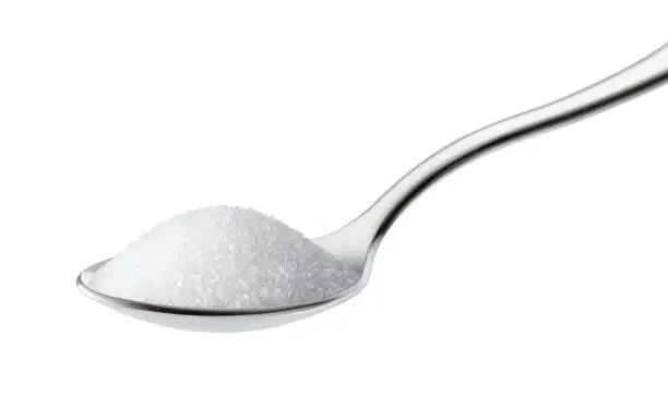 Teaspoon of sugar on white background.