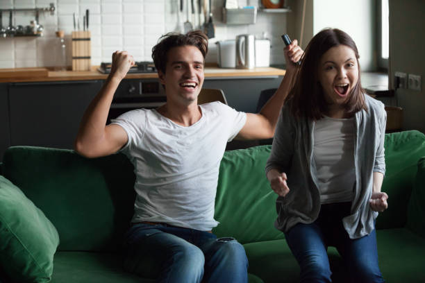 istock Happy young couple watching tv at home 1069463188