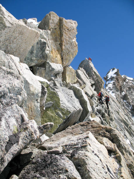 istock jagged rock and snow mountain ridge with three mountain climbers in the background 1069466148